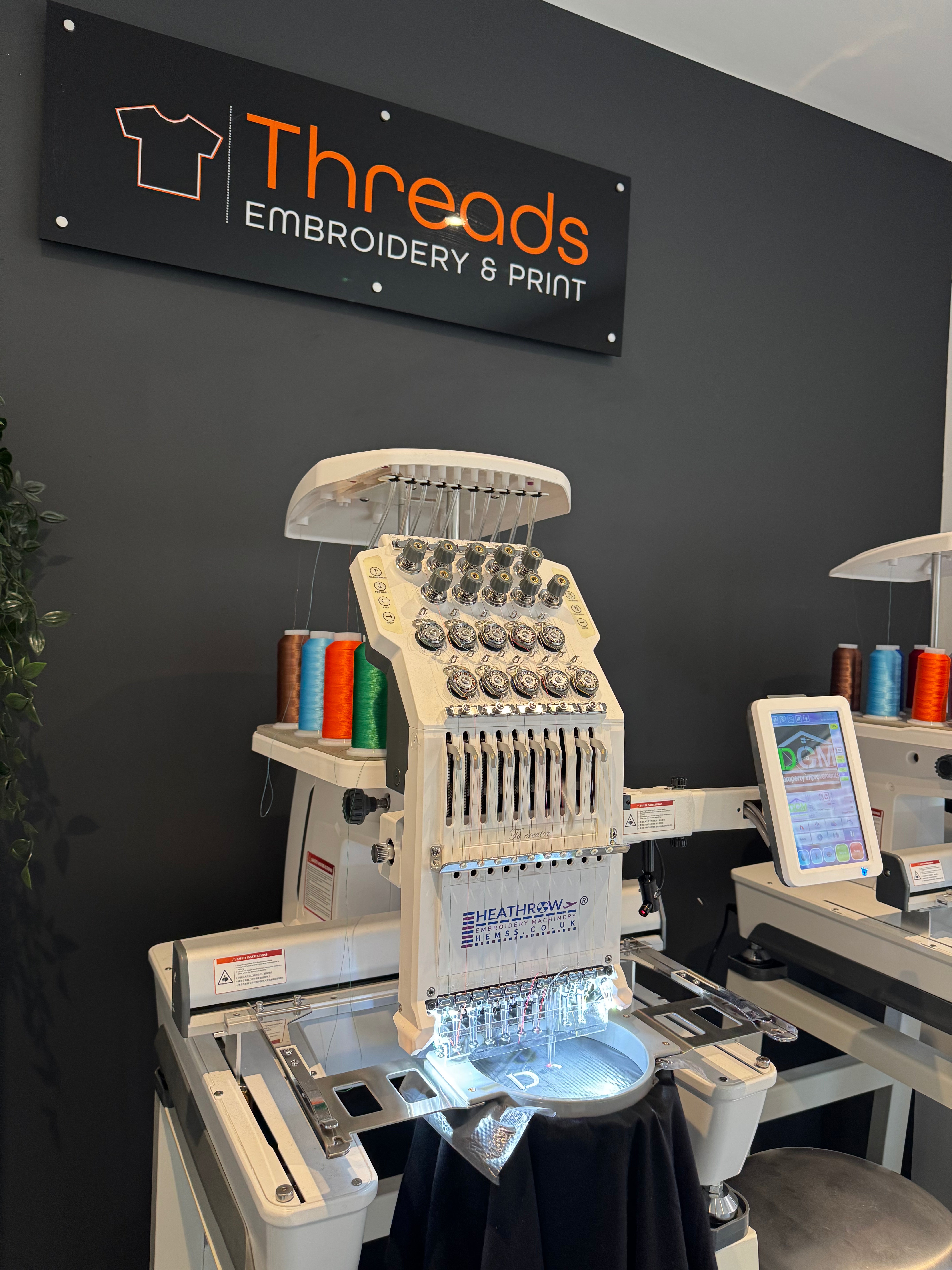 Embroidery machine stitching a branded garment